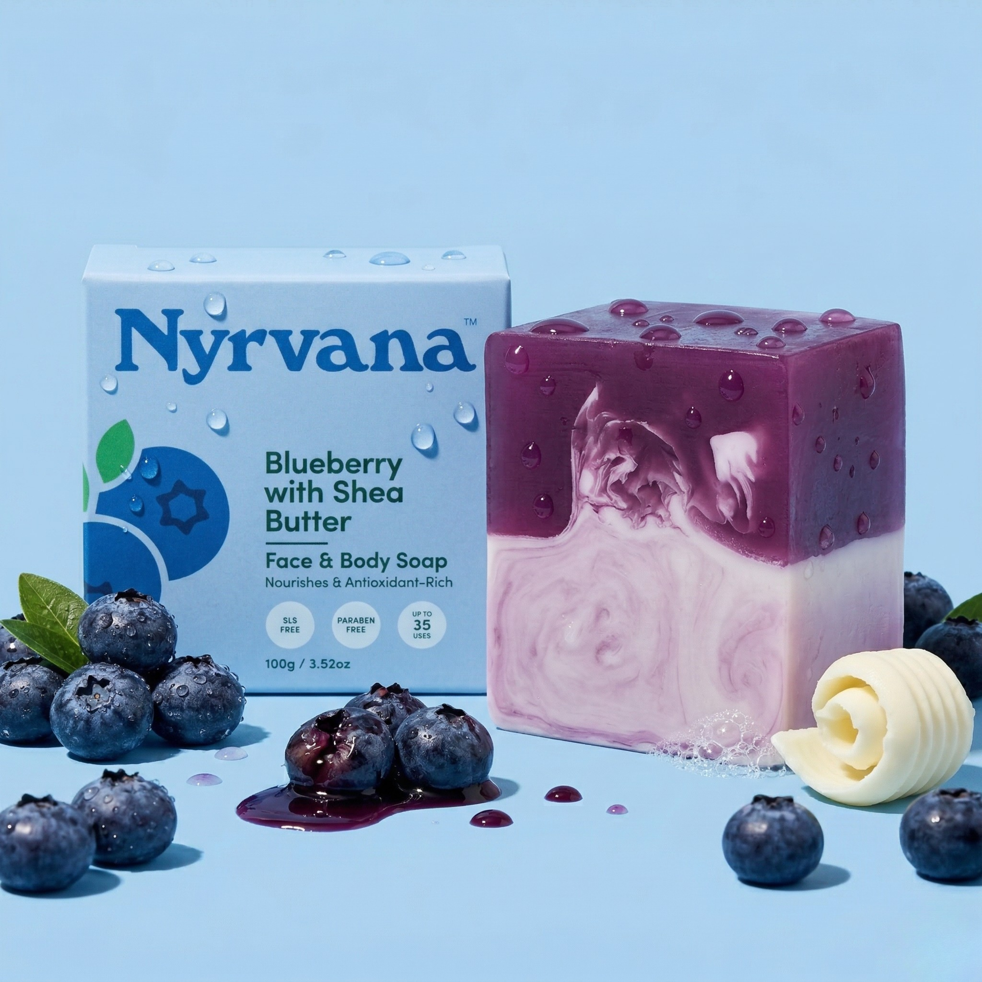 Nyrvana Blueberry Shea Butter Soap 100g with box surrounded by fresh blueberries and shea butter curl on blue background with water droplets