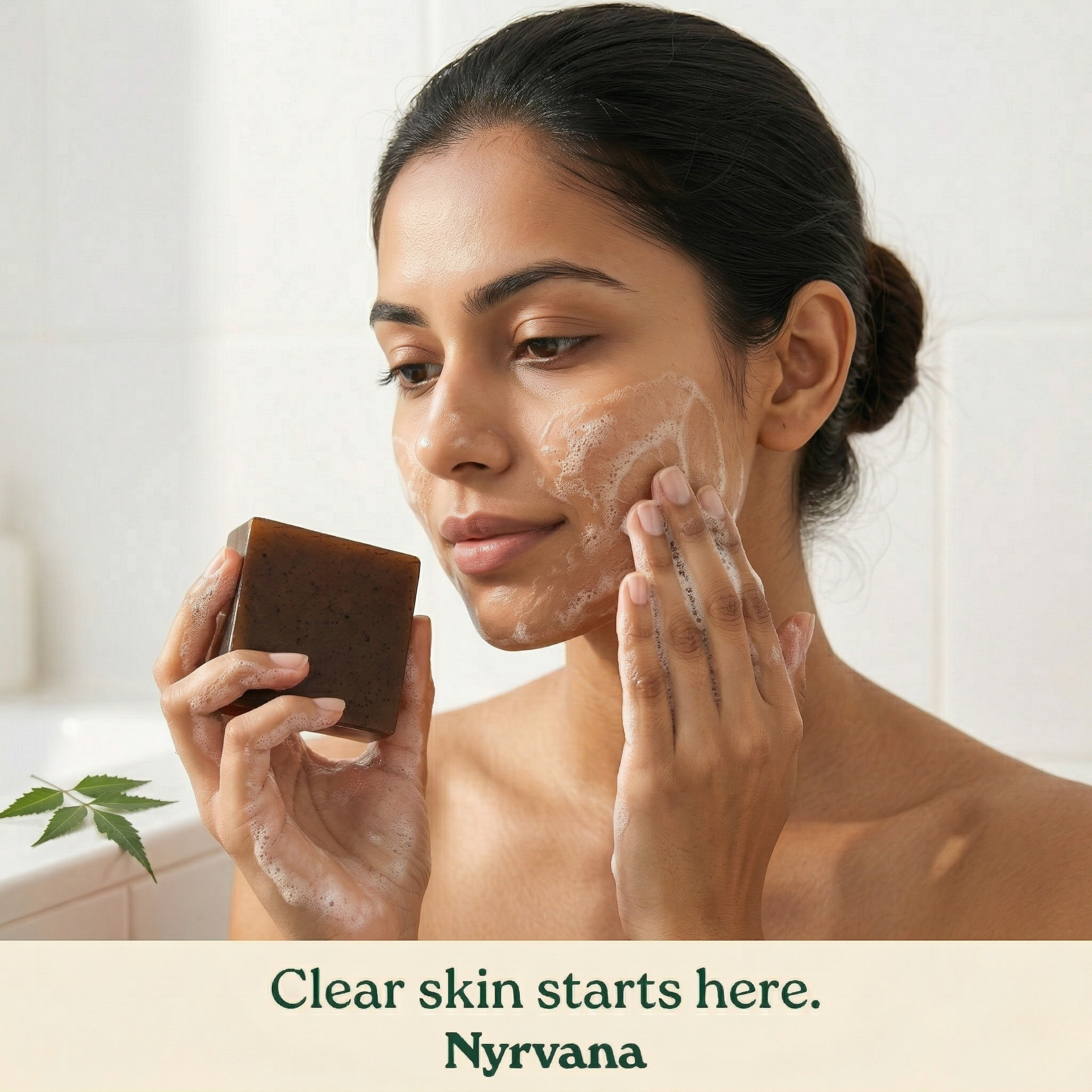 Woman lathering Nyrvana Neem Tea Tree Soap on face with neem leaf in foreground in clean bathroom setting