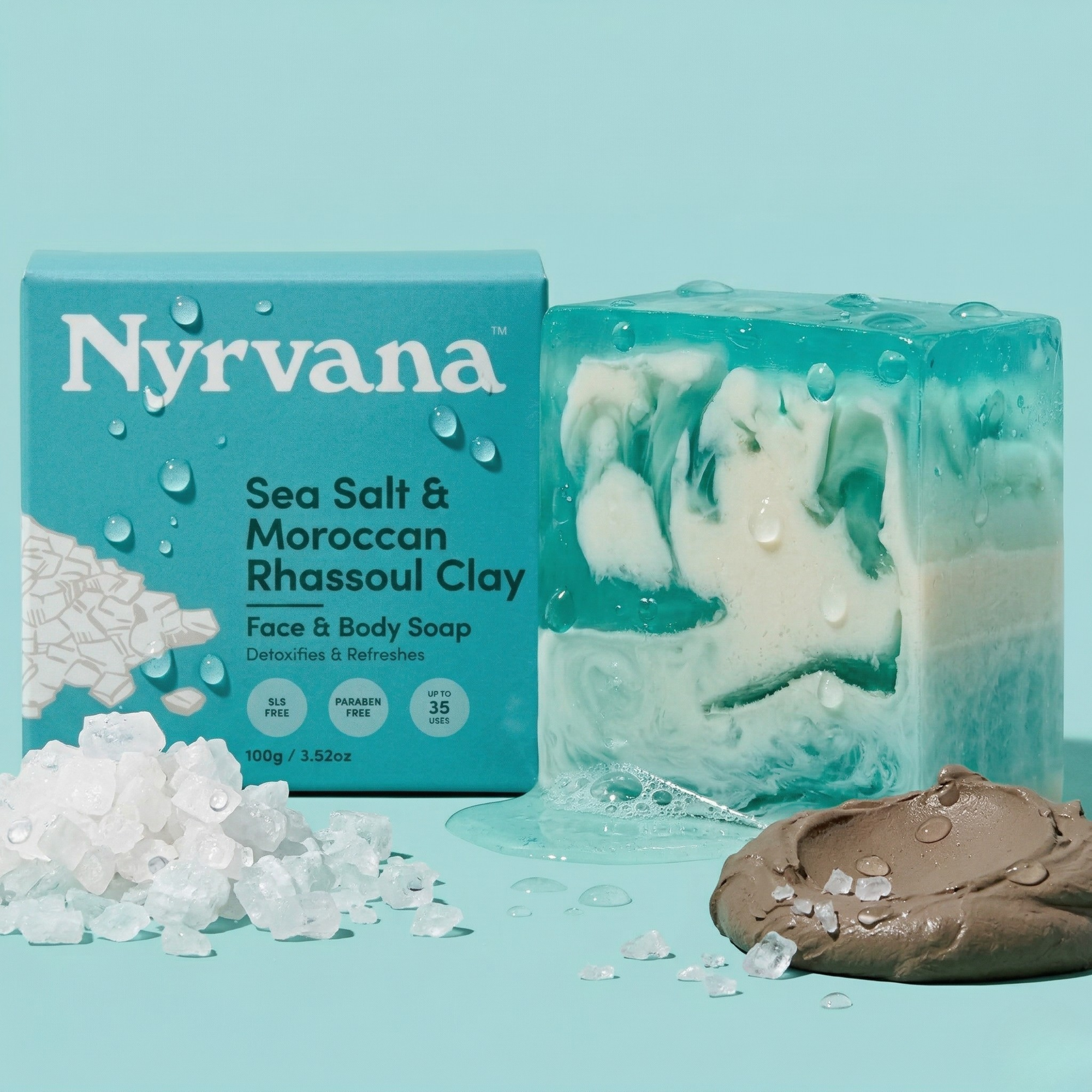 Nyrvana Sea Salt Rhassoul Clay Soap 100g with box surrounded by sea salt crystals and Moroccan rhassoul clay on teal background with water droplets